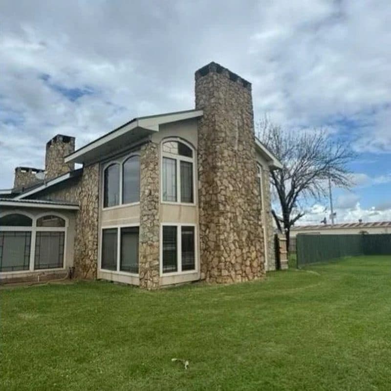 Stone chimney and house exterior before and after a soft wash by Ascension Exteriors