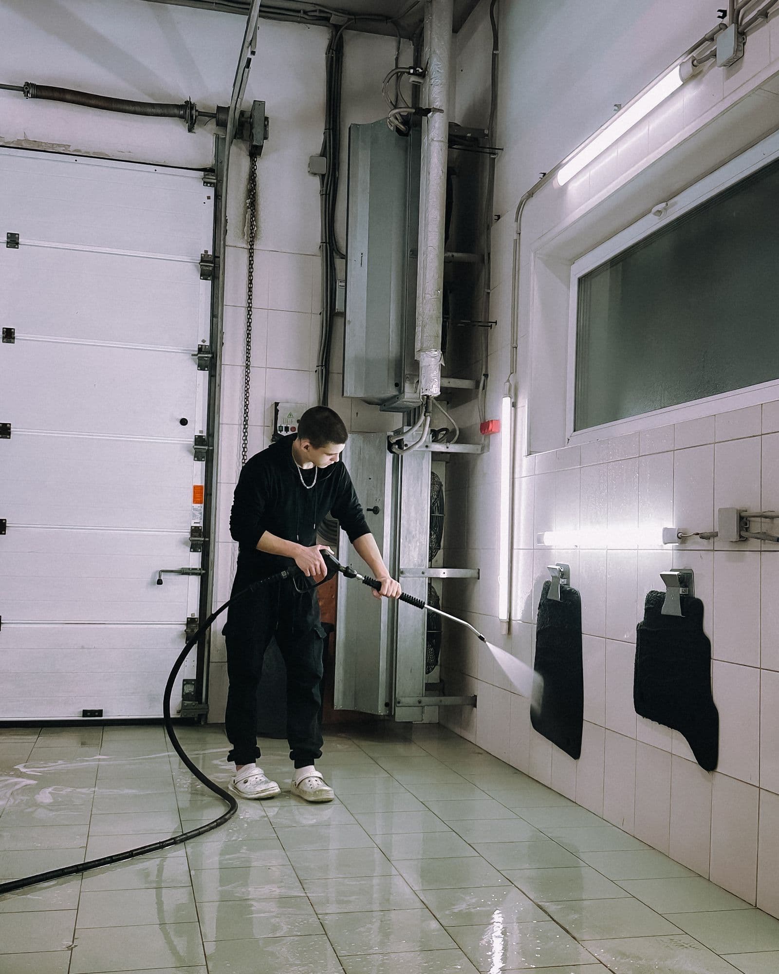 A service bay floor being washed down, the kind of surface where oil and grease collect